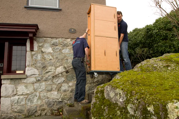 Foster's movers transporting a cabinet into secure storage