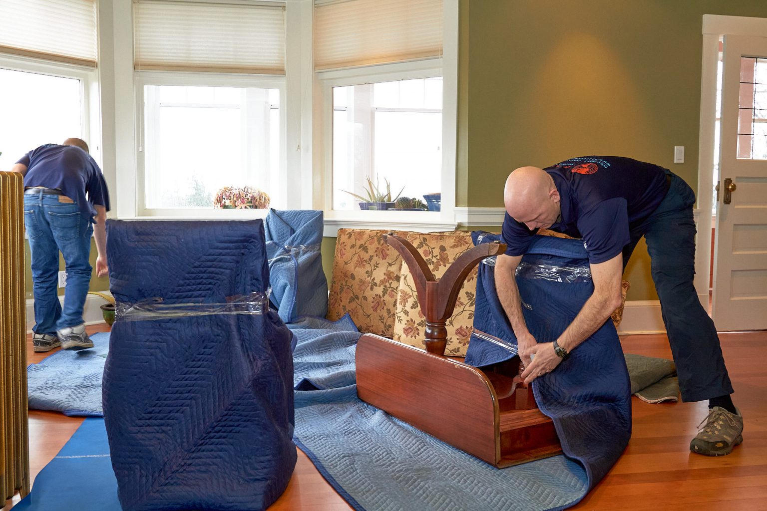 Foster's movers blanket-wrapping furniture for a move
